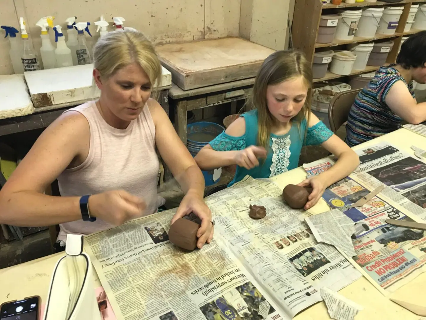 Adults and children crafting with clay together.