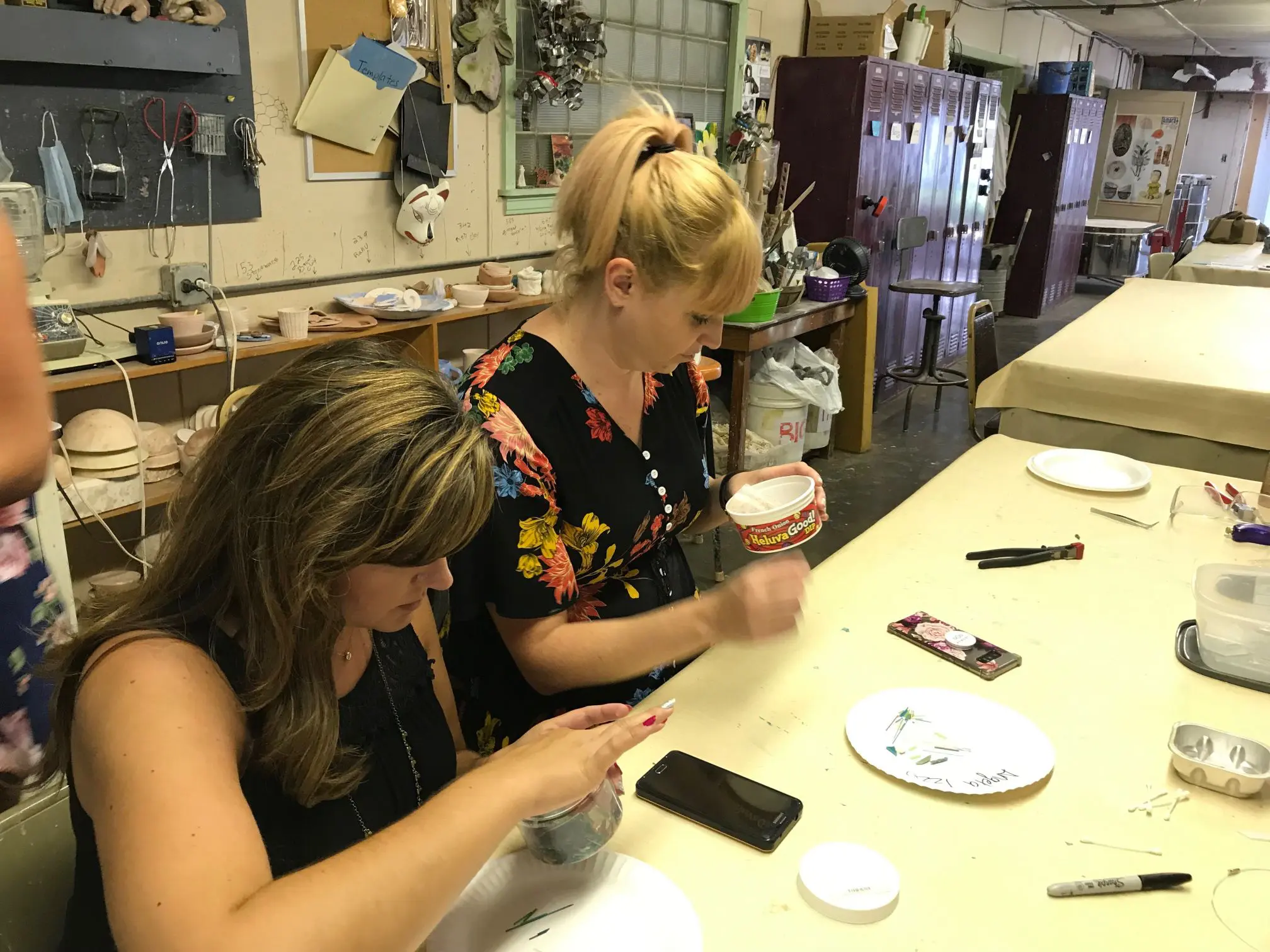 Women painting pottery in an art studio.